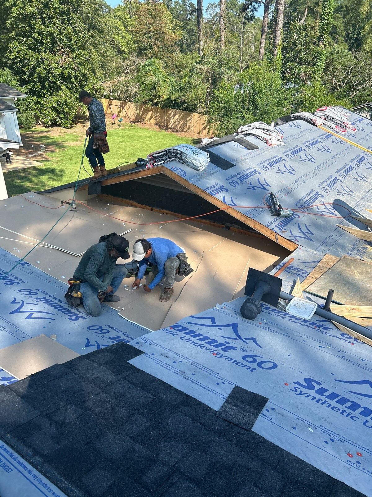 Dickerson crew laying synthetic underlayment on a residential roof