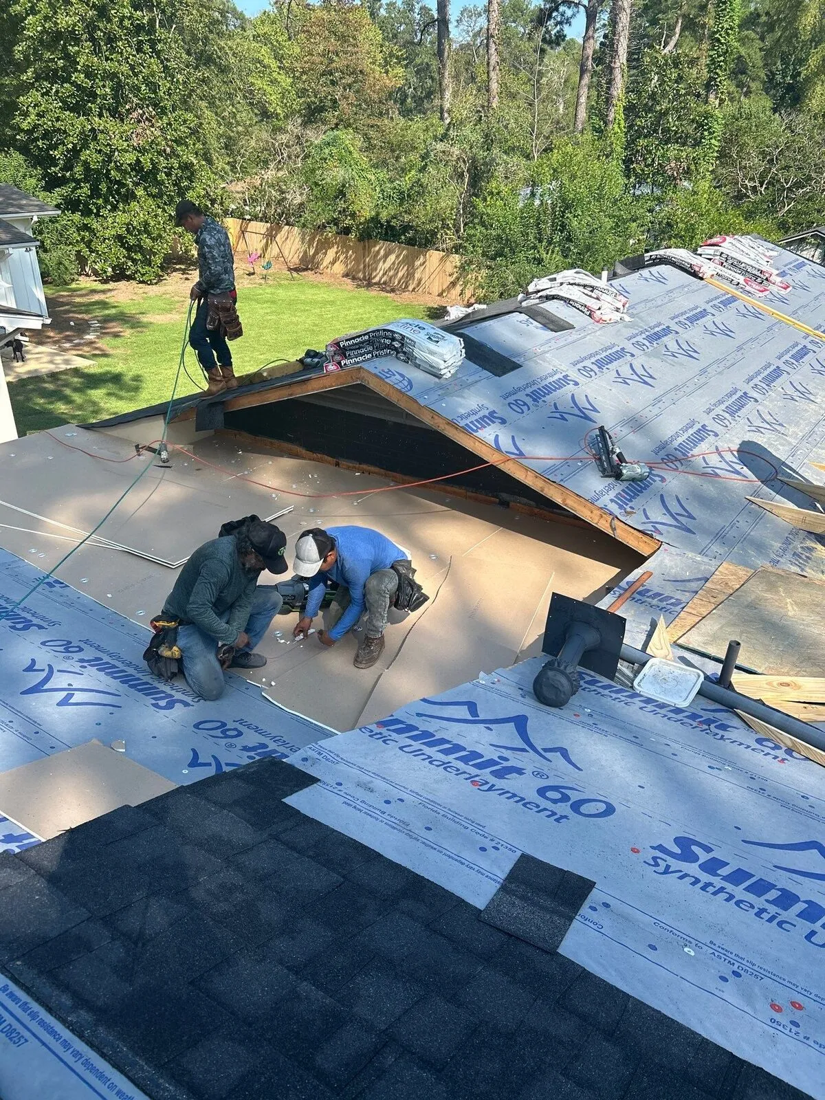 Dickerson crew laying synthetic underlayment on a residential roof