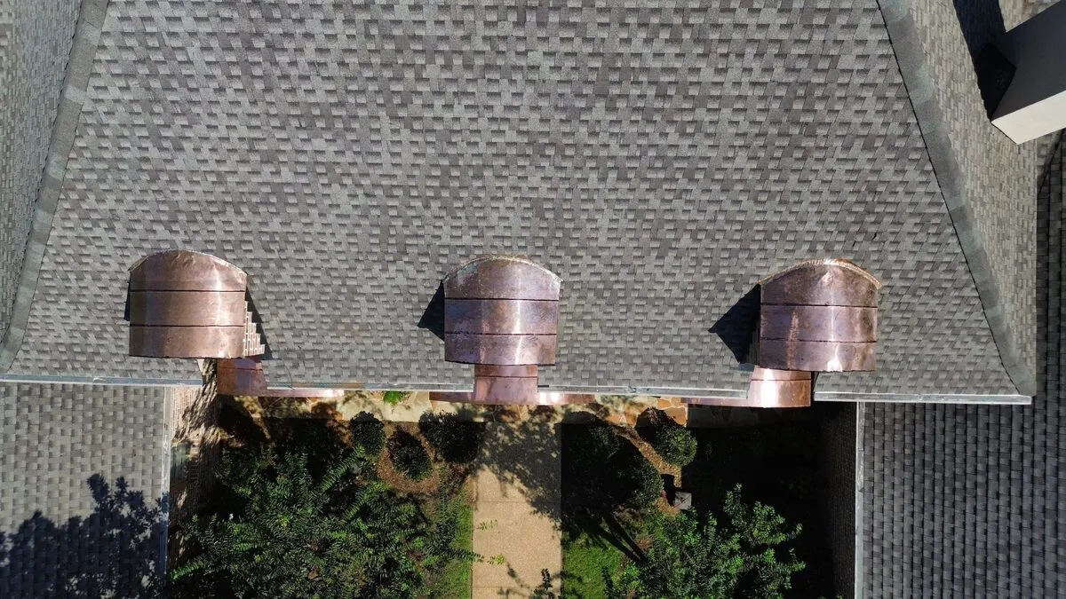 Copper-topped dormers set into a fresh architectural shingle roof
