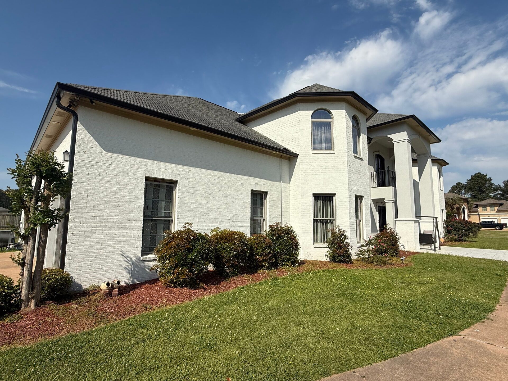 Finished roof on a white painted-brick two-story home