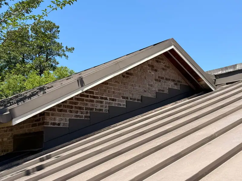 Standing seam metal roof over a brick gable