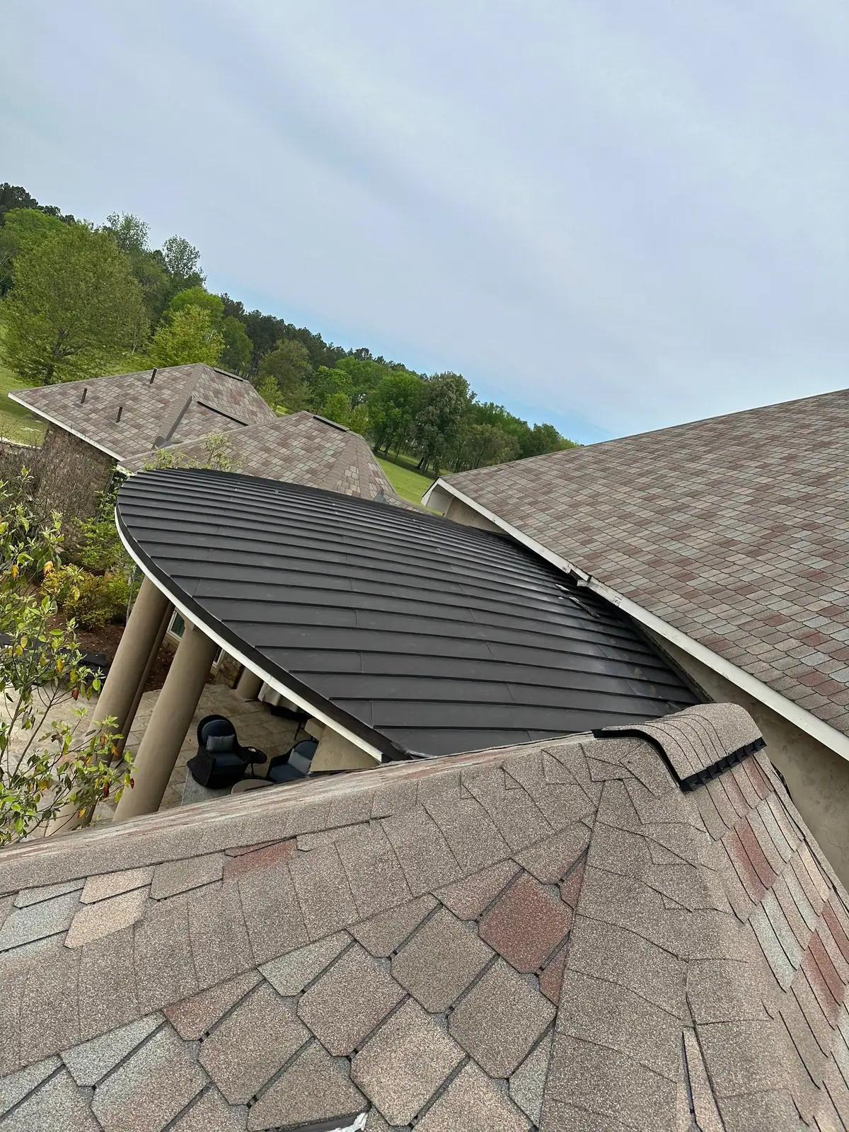 New metal roof section tying into a shingle roof, metal roofing by Dickerson Contracting in Brandon, MS
