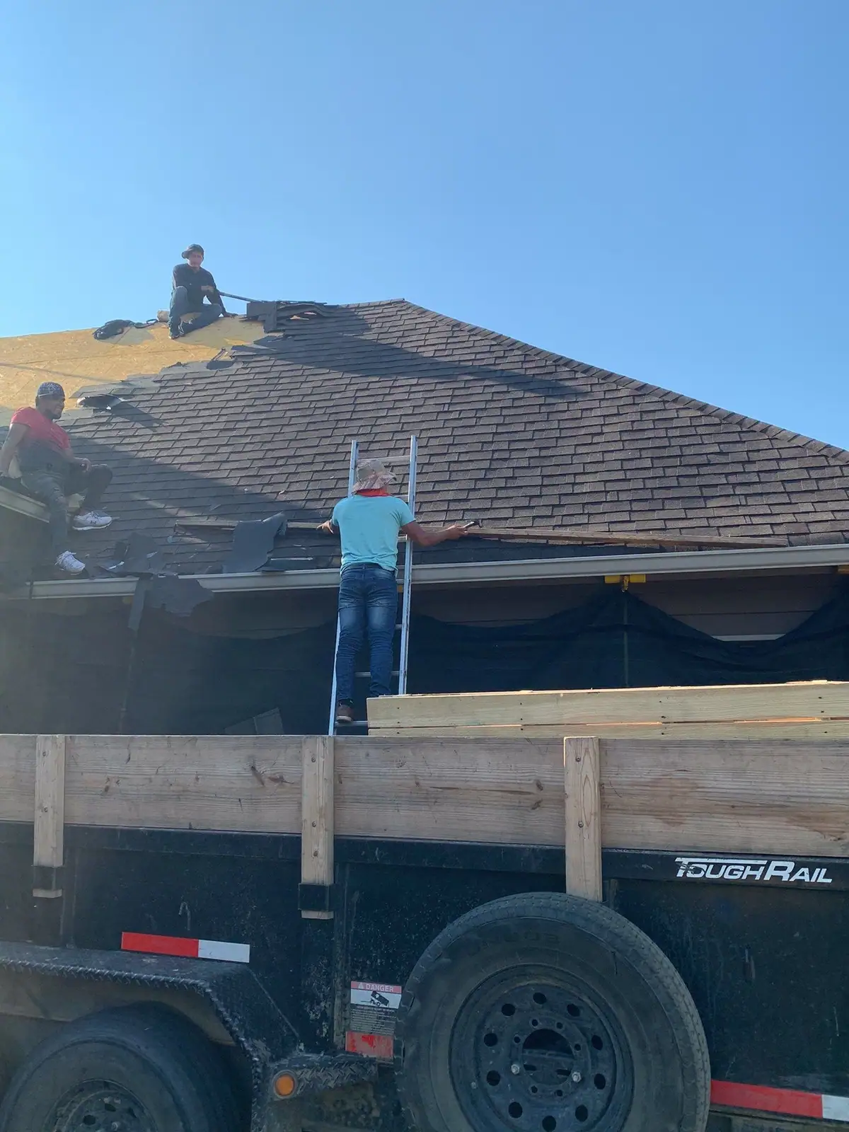 Roofers working on a shingle roof, residential roofing by Dickerson Contracting in Madison, MS