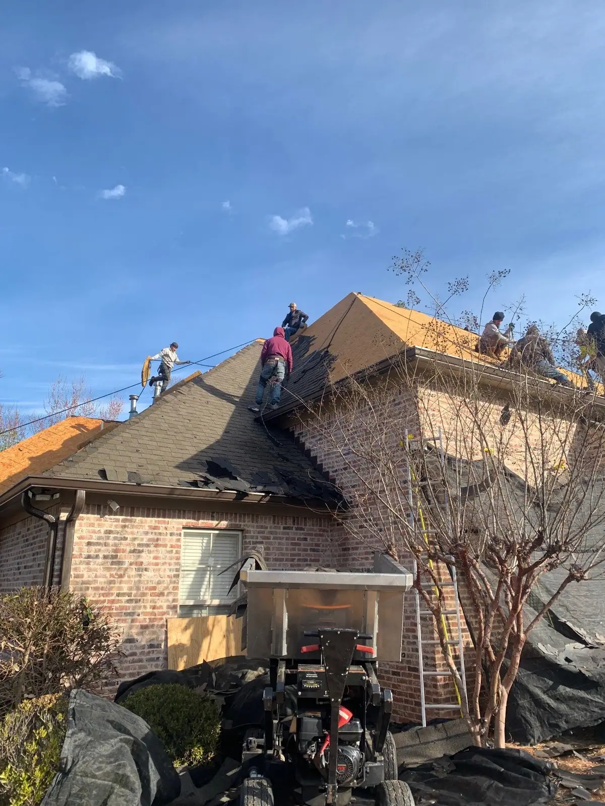 Roofers mid-way through a shingle roof replacement, residential roofing by Dickerson Contracting in Brandon, MS