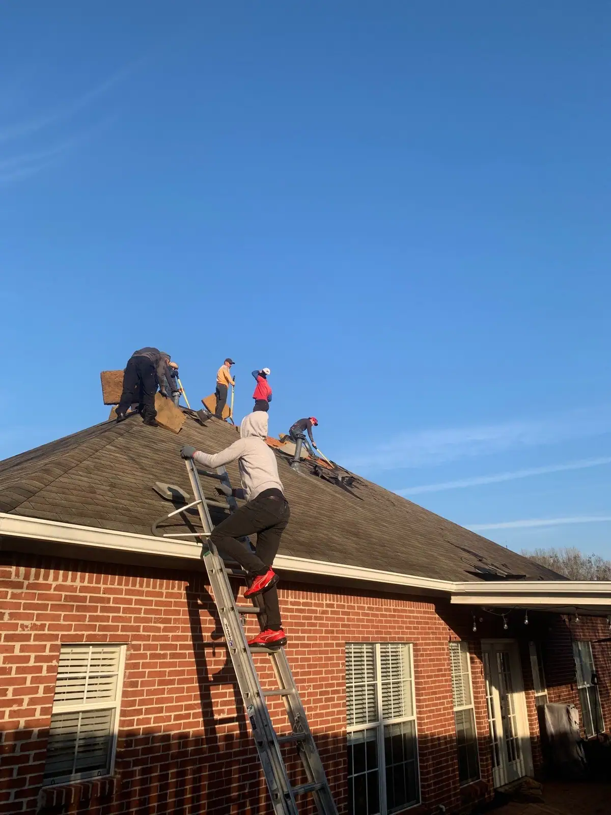 Roofers at work on a shingle roof in Brandon, MS, by roofing company Dickerson Contracting