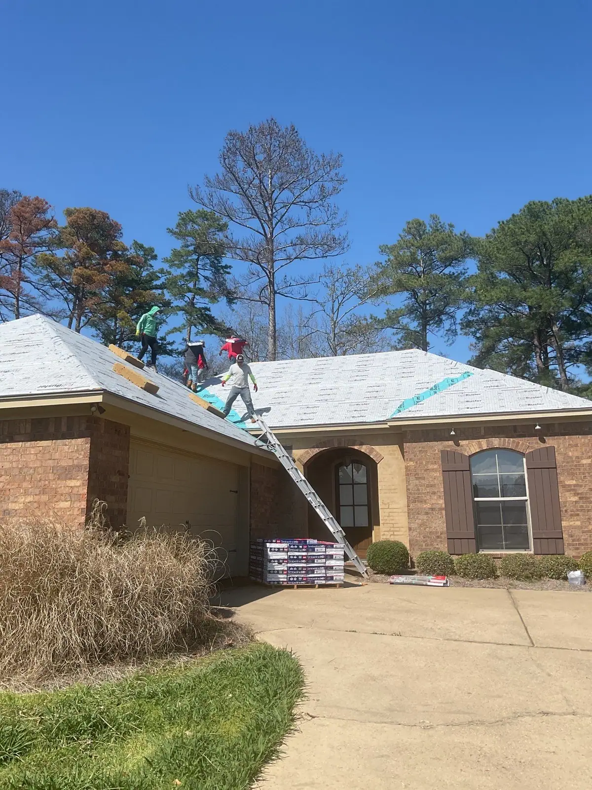 Roofers installing new shingles in Flowood, MS, by roofing company Dickerson Contracting