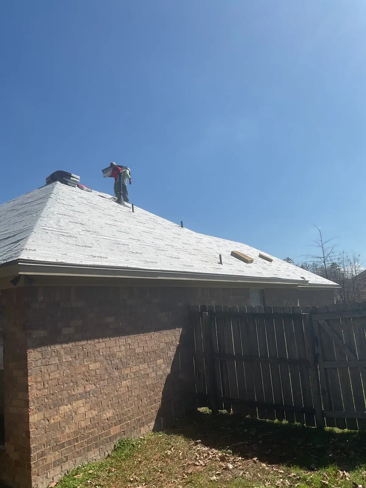 Roofers nailing down new shingles in Flowood, MS, by roofing company Dickerson Contracting