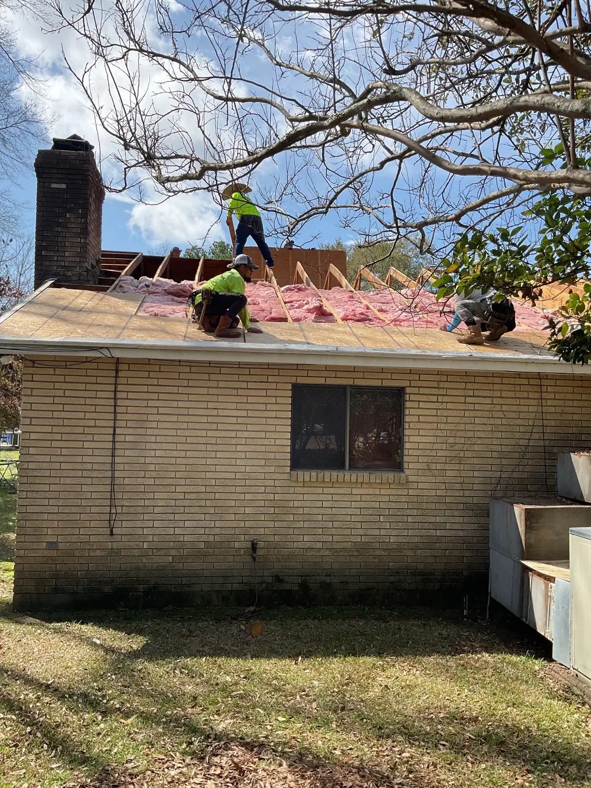 Roofers working across the roof decking, roof repair and replacement by Dickerson Contracting in Jackson, MS