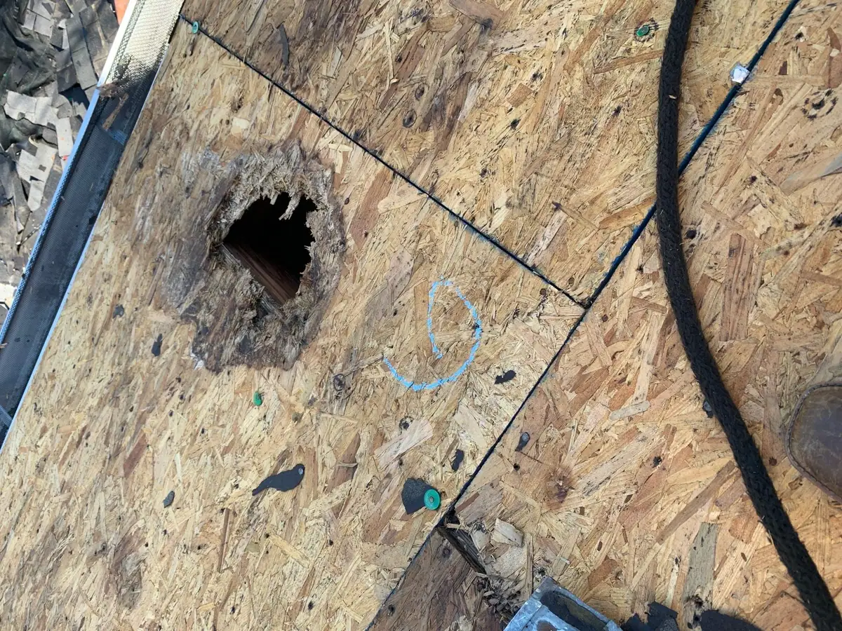Rotted hole in roof decking found during a residential roofing tear-off