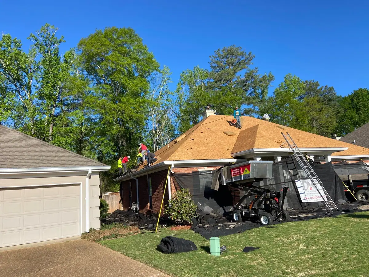 Roofers and equipment on a shingle roof, roof repair and replacement by Dickerson Contracting in Brandon, MS
