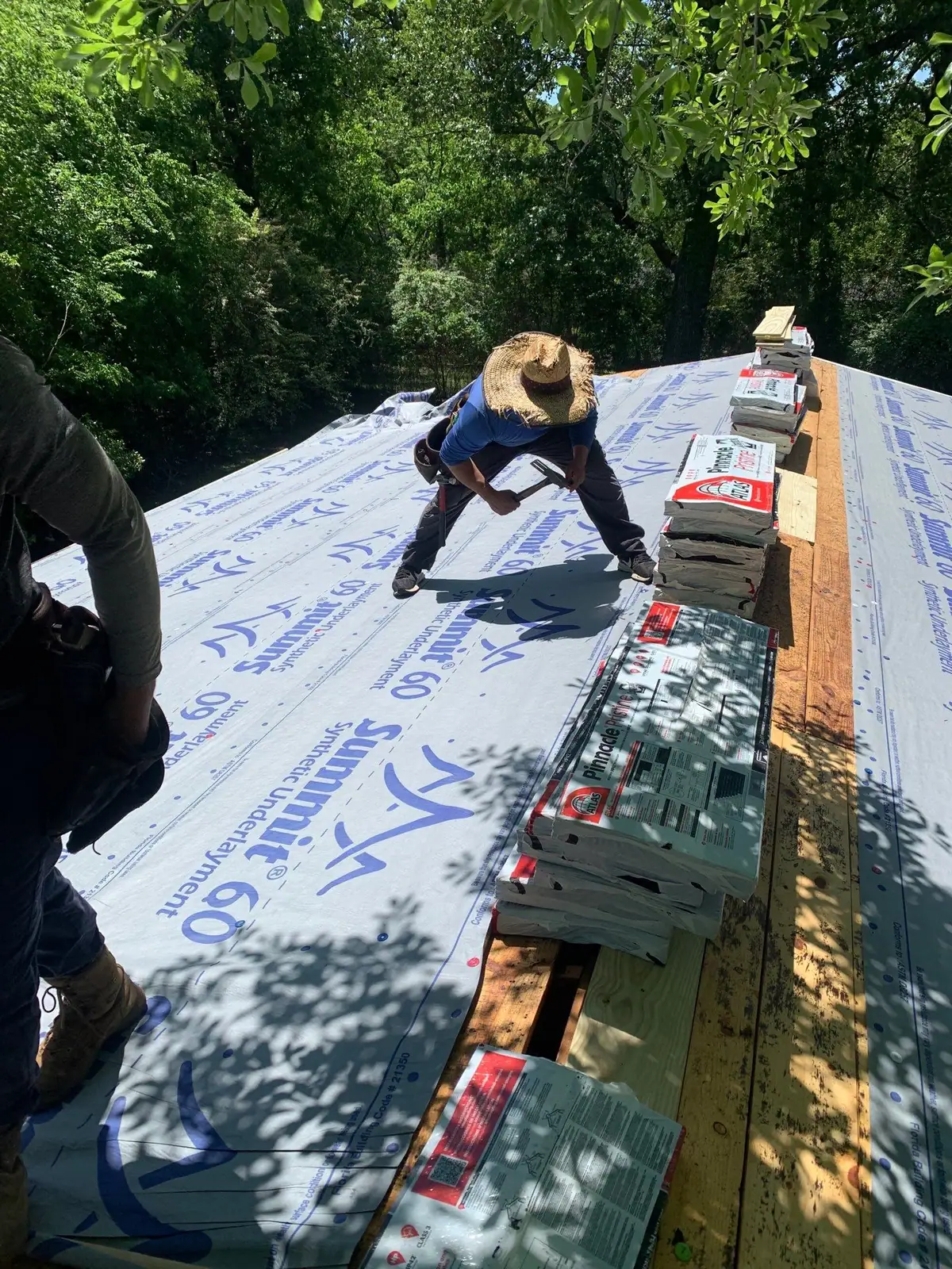 Roofer laying underlayment on a roof in Clinton, MS, by roofing company Dickerson Contracting