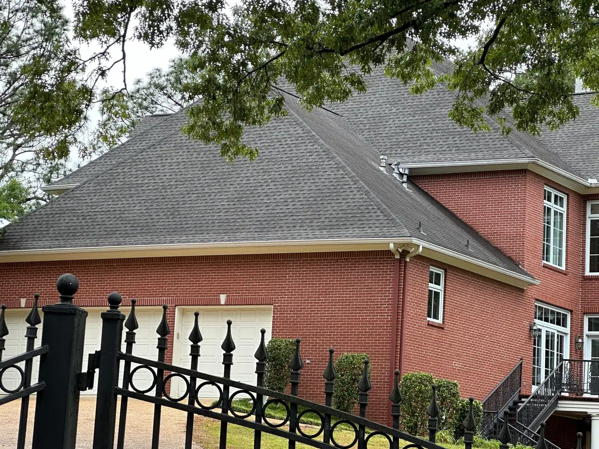 Large brick two-story home with a new shingle roof, residential roofing replacement