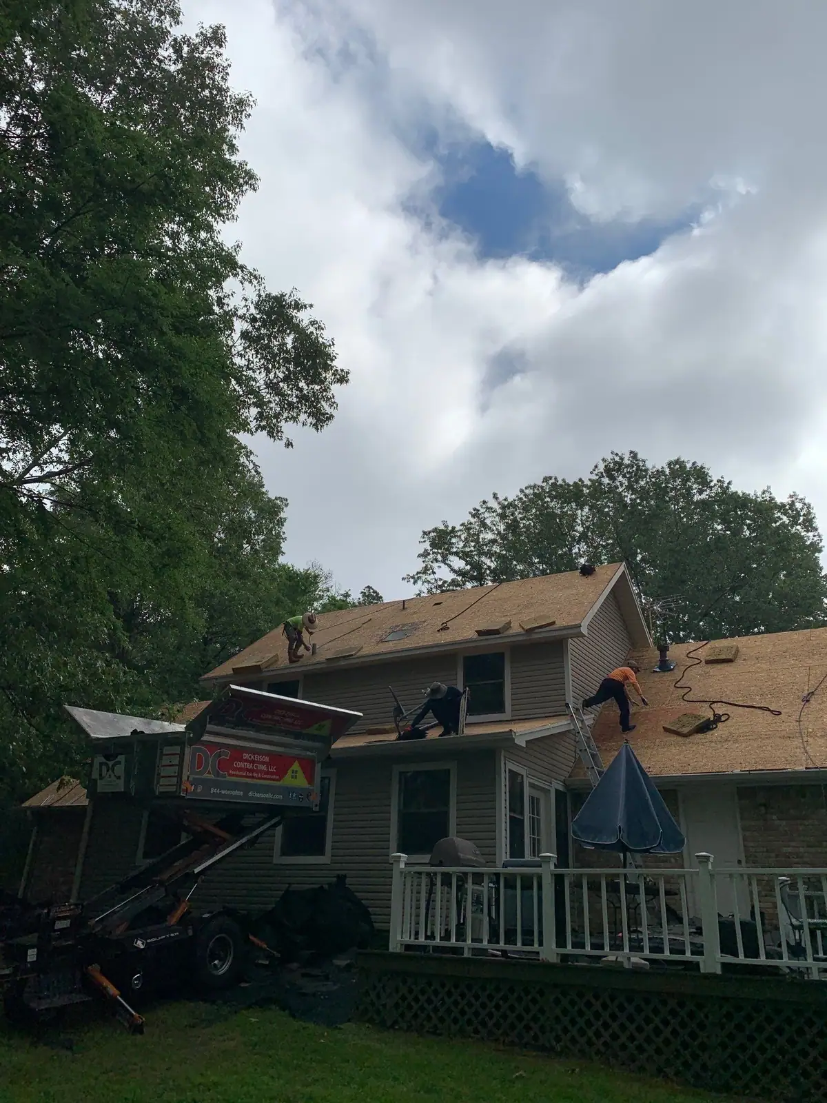 Roofers working on a shingle roof, residential roofing by Dickerson Contracting in Clinton, MS