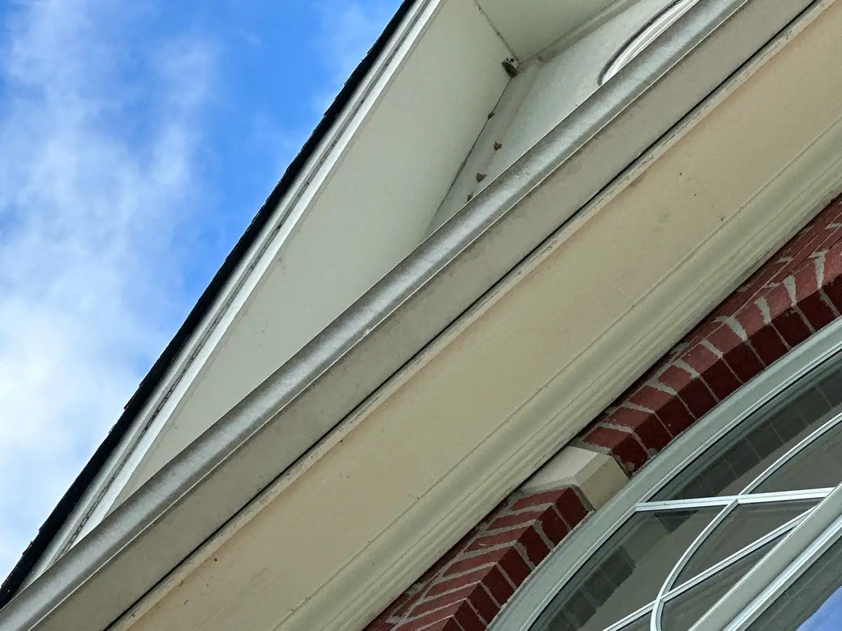 New white soffit and fascia along a gable edge above a brick wall