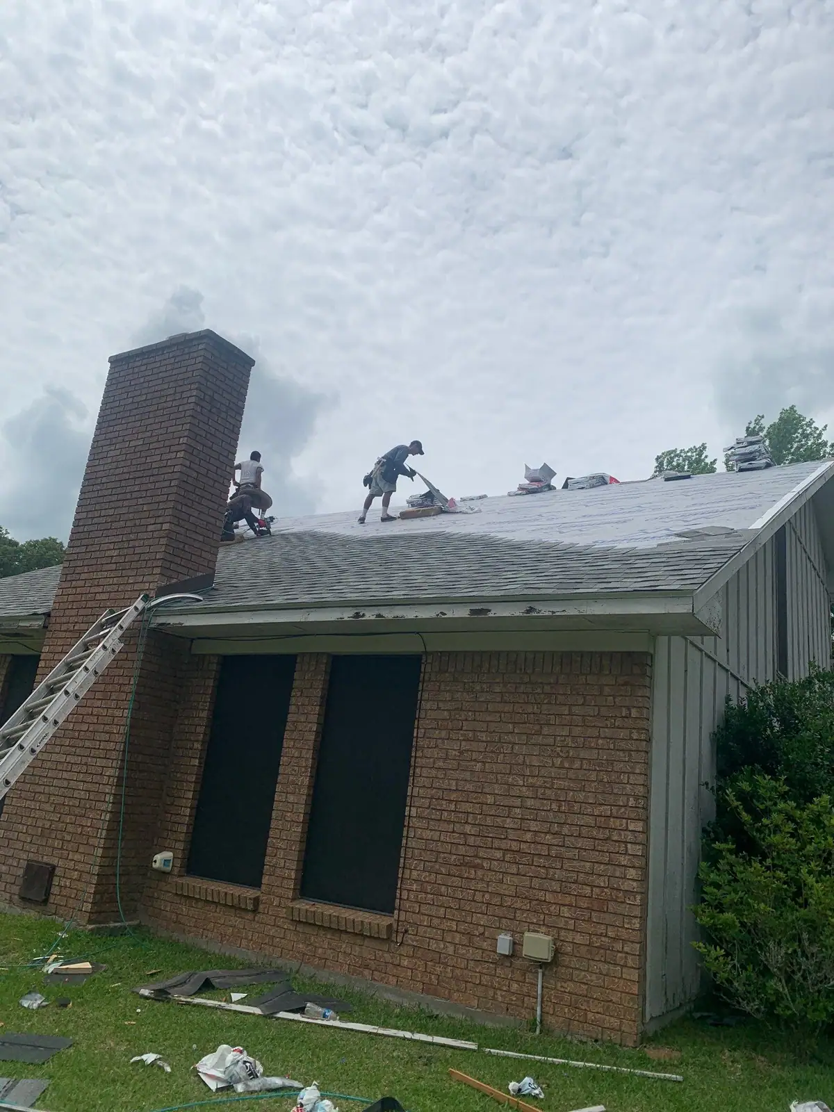 Roofers working on a shingle roof, roof repair and replacement by Dickerson Contracting in Pearl, MS