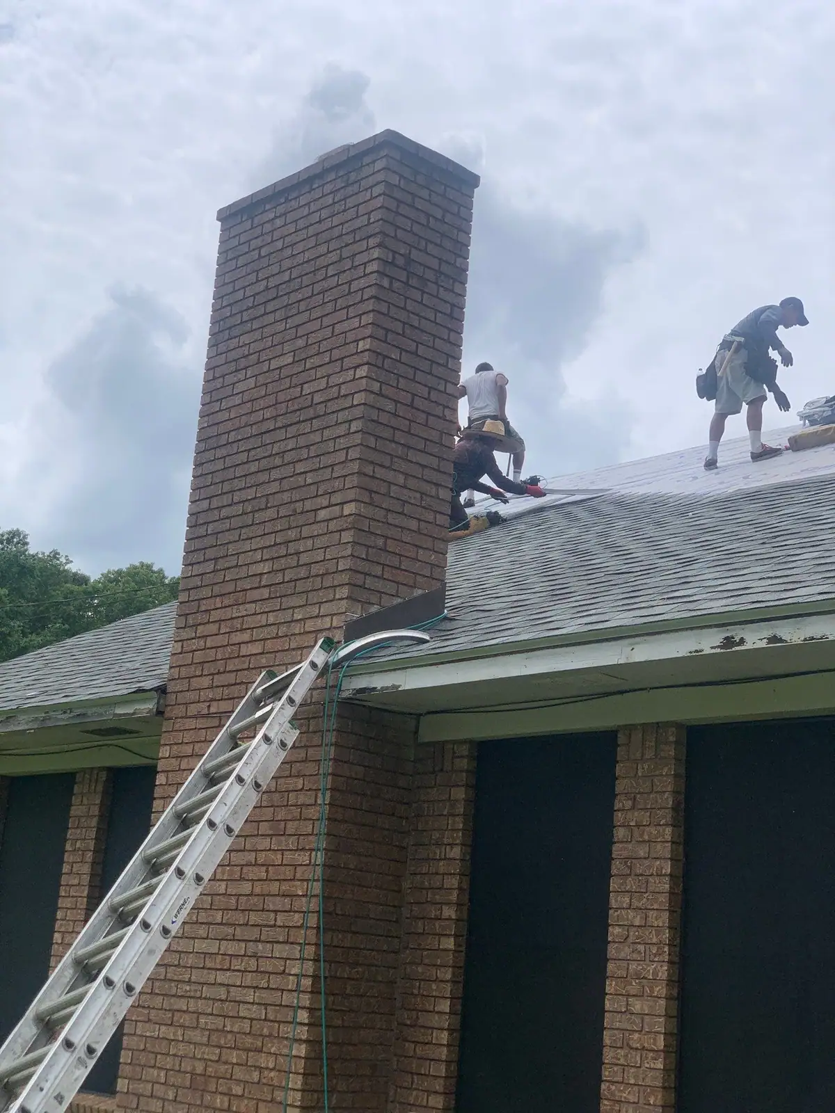 Roofers working on a shingle roof, residential roofing by Dickerson Contracting in Pearl, MS