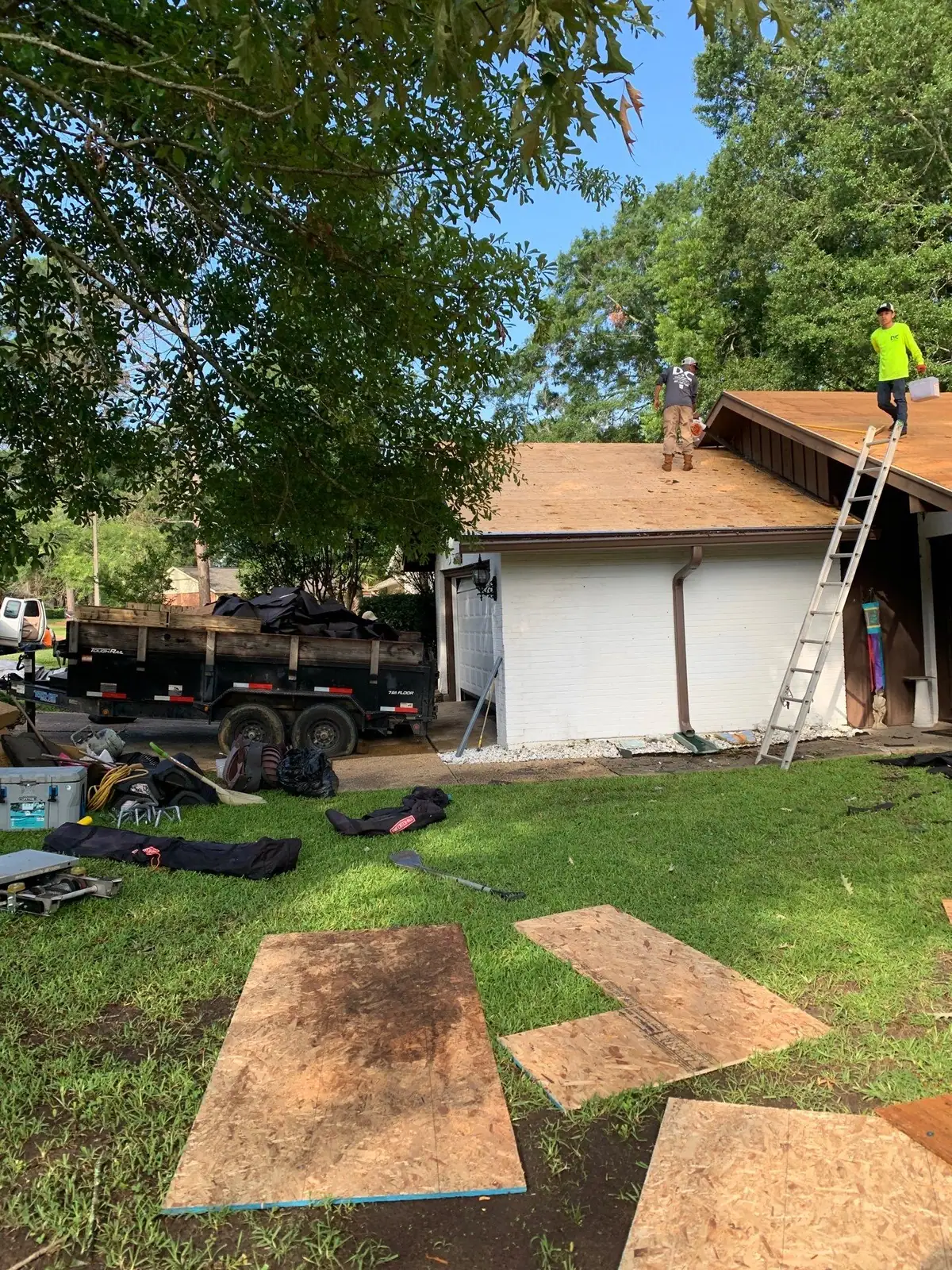 Roofers mid-way through a shingle roof replacement, roof repair and replacement by Dickerson Contracting in Clinton, MS