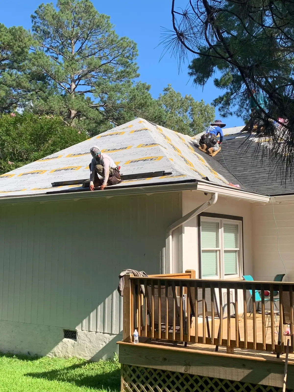 Roofers installing new shingles in Jackson, MS, by roofing company Dickerson Contracting