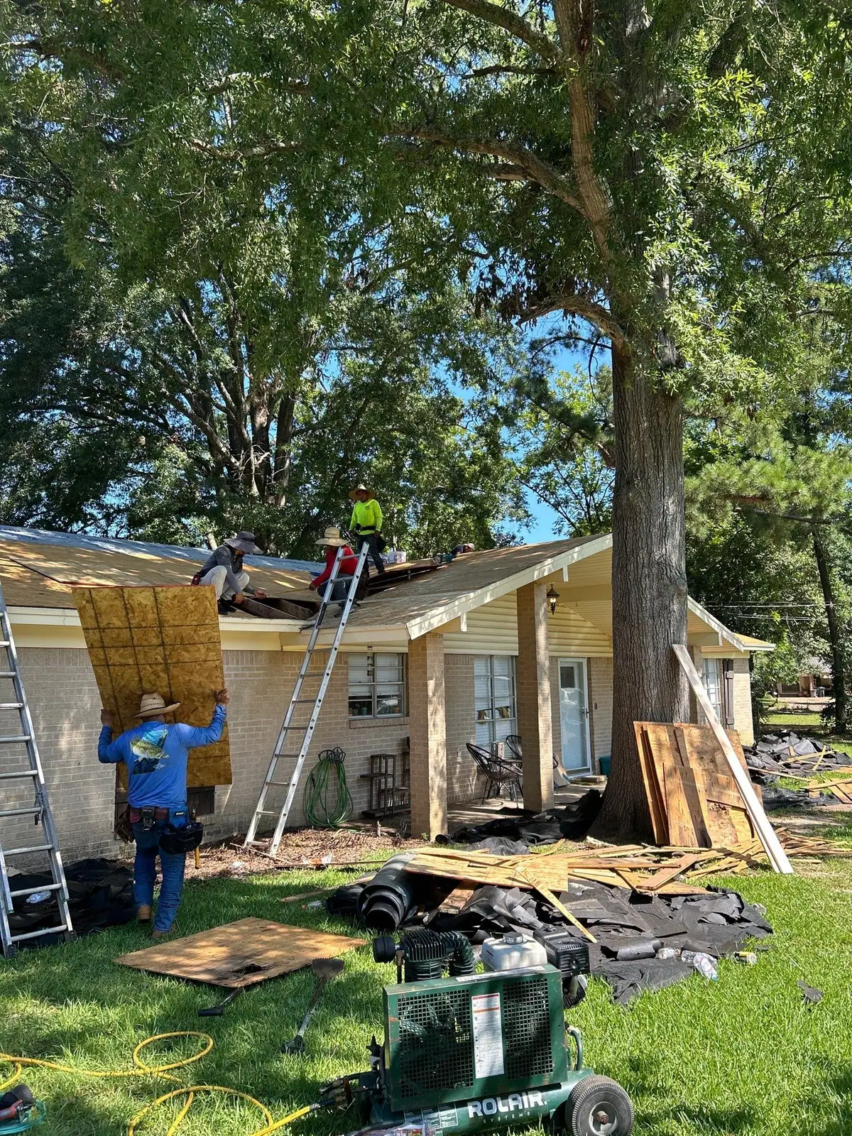 Roofers working on a shingle roof in Pearl, MS, by roofing company Dickerson Contracting
