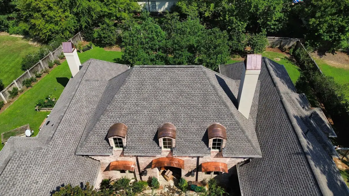 Brick home with three copper eyebrow dormers and a new shingle roof, residential roofing from above
