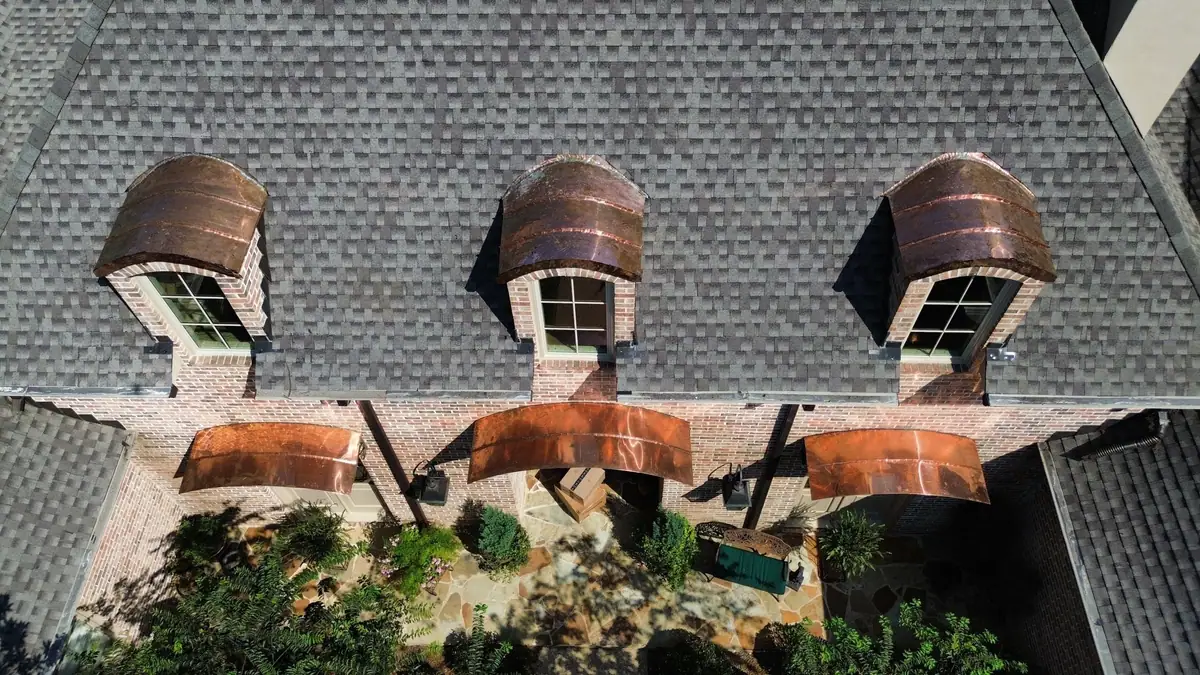 Copper eyebrow dormers, a metal roofing detail on a Dickerson Contracting roof