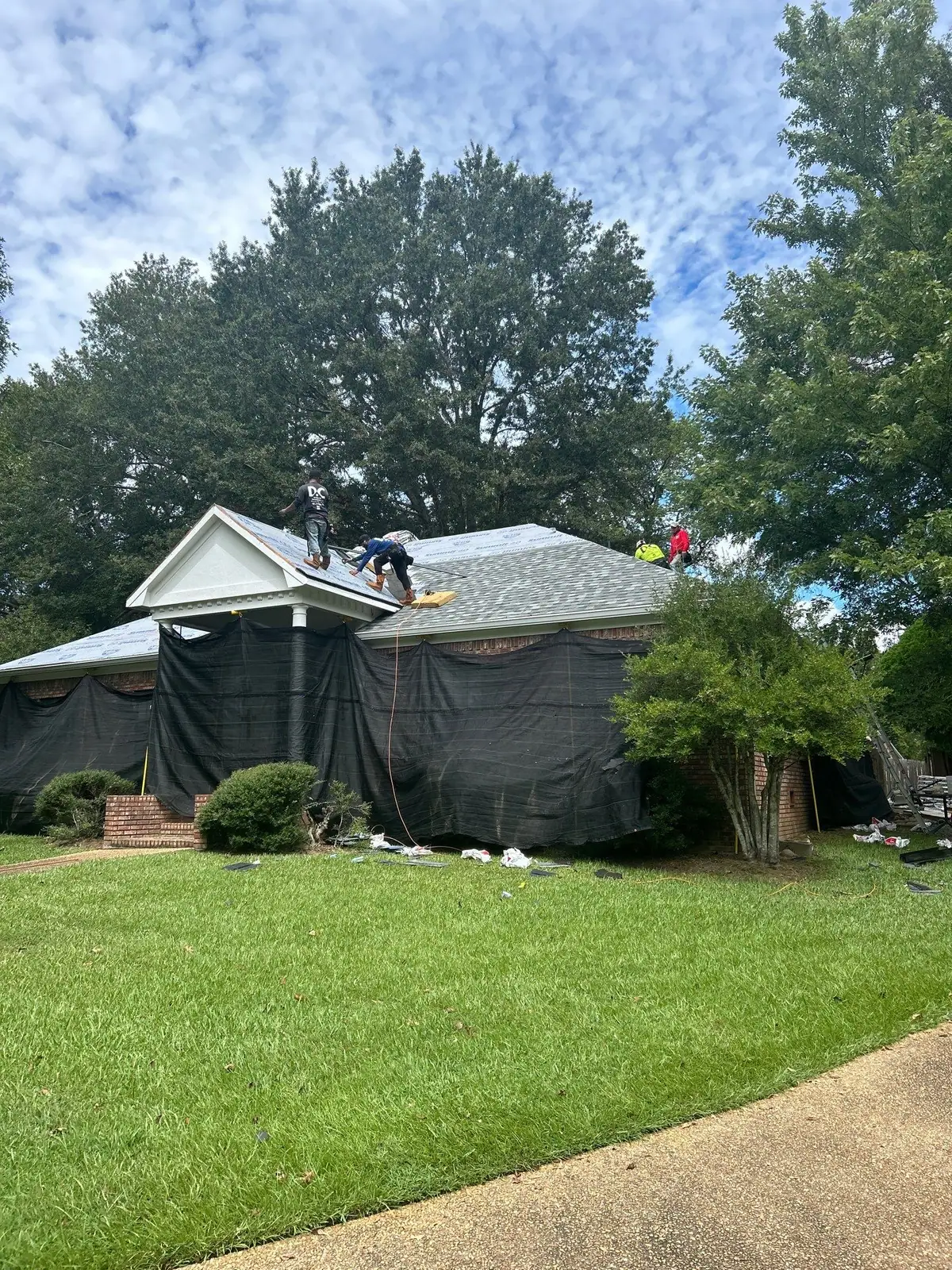 Roofers working on a shingle roof, roof repair and replacement by Dickerson Contracting in Ridgeland, MS
