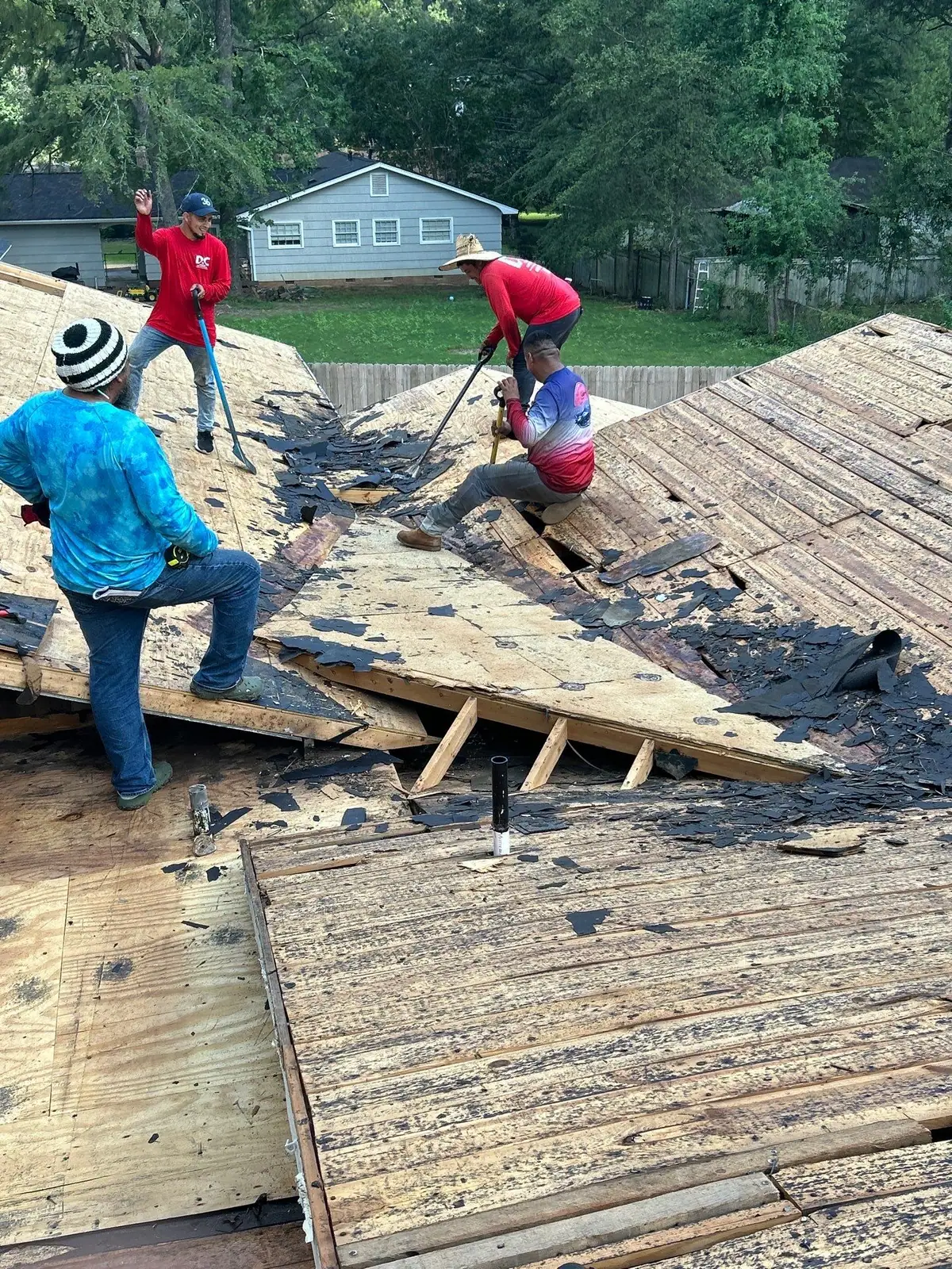 Roofers replacing a shingle roof in Jackson, MS, by roofing company Dickerson Contracting