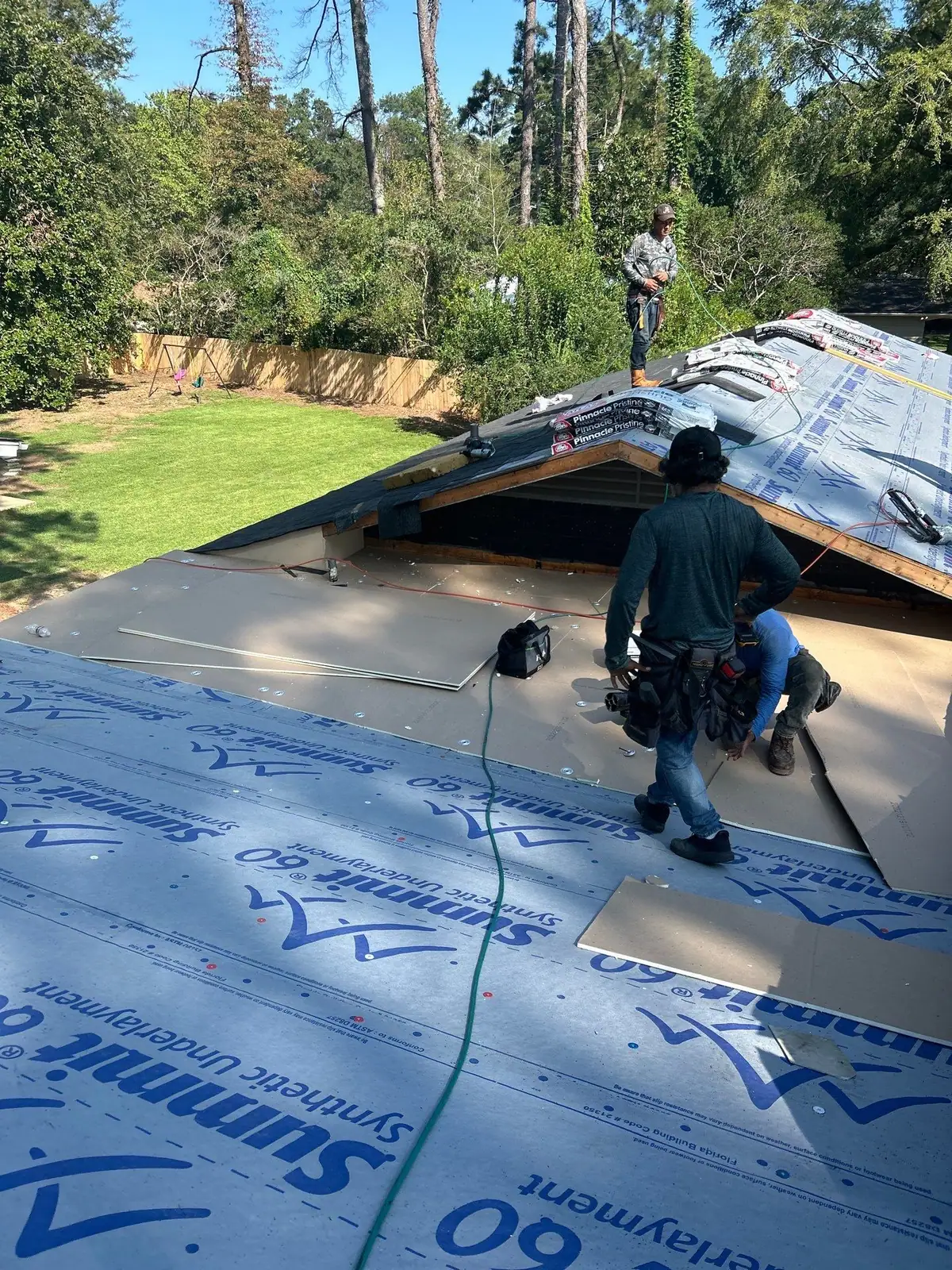 Roofers nailing down new shingles in Jackson, MS, by roofing company Dickerson Contracting