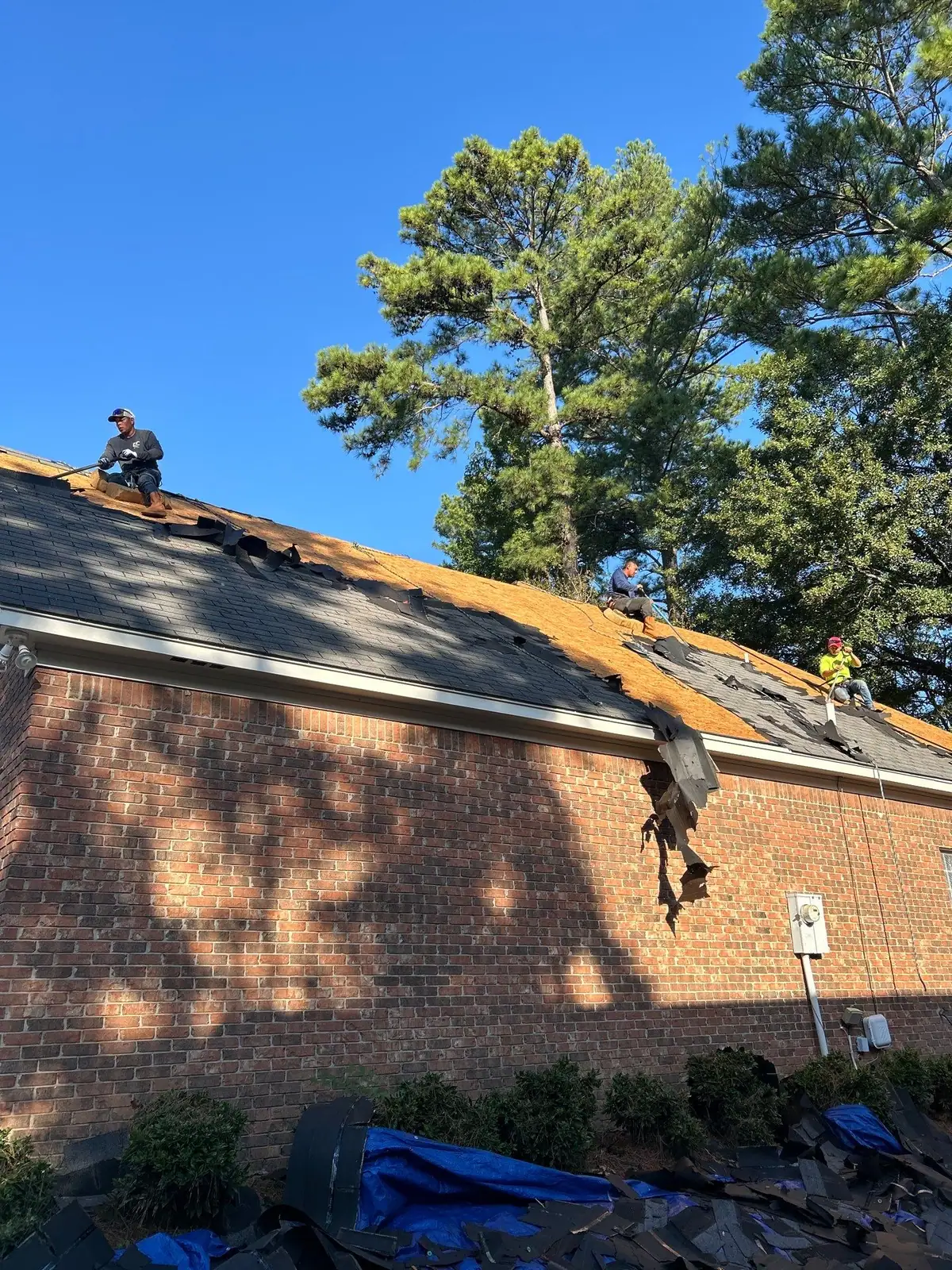 Roofers replacing a shingle roof in Ridgeland, MS, by roofing company Dickerson Contracting