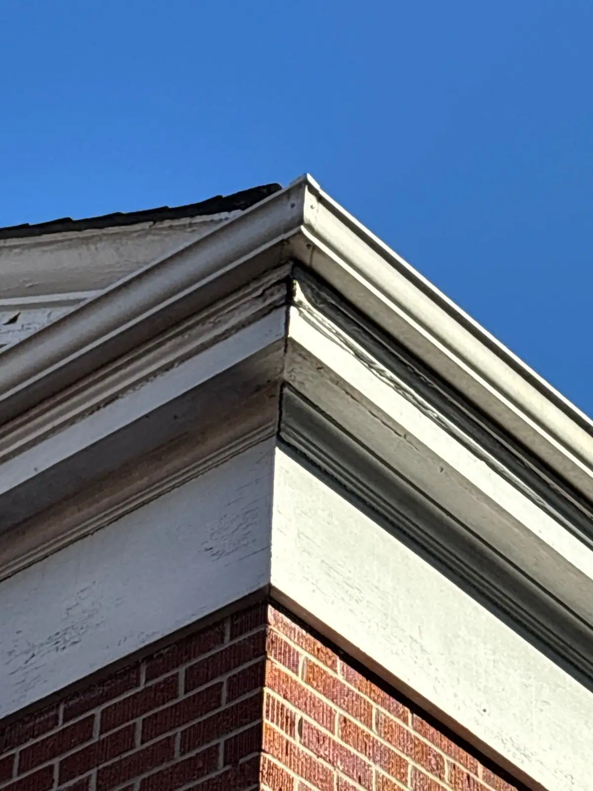 Finished crown trim and fascia at a brick building corner