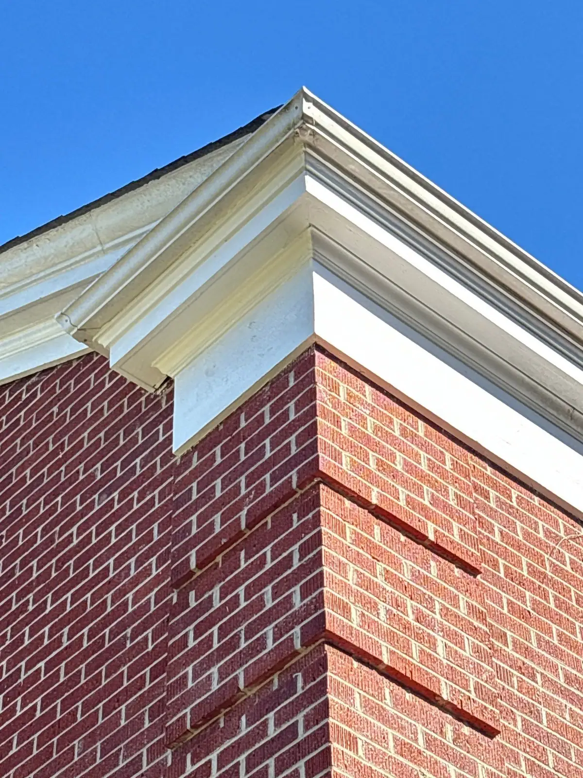 Finished white cornice return with new fascia on a red brick corner
