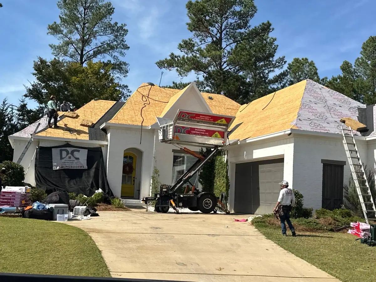 Roofers and equipment on a shingle roof, roof repair and replacement by Dickerson Contracting in Madison, MS