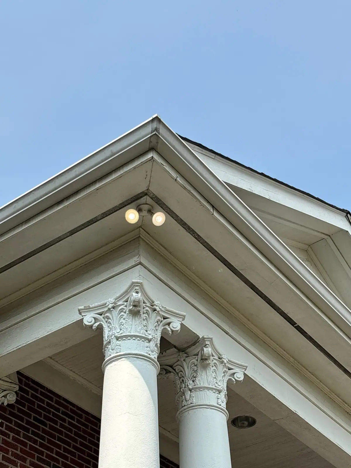 White gable trim and soffit above a pair of columns
