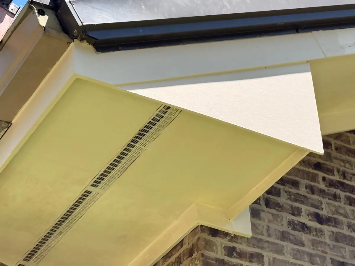 New painted soffit with a continuous vent strip under a church roof edge, soffit repair by Dickerson Contracting
