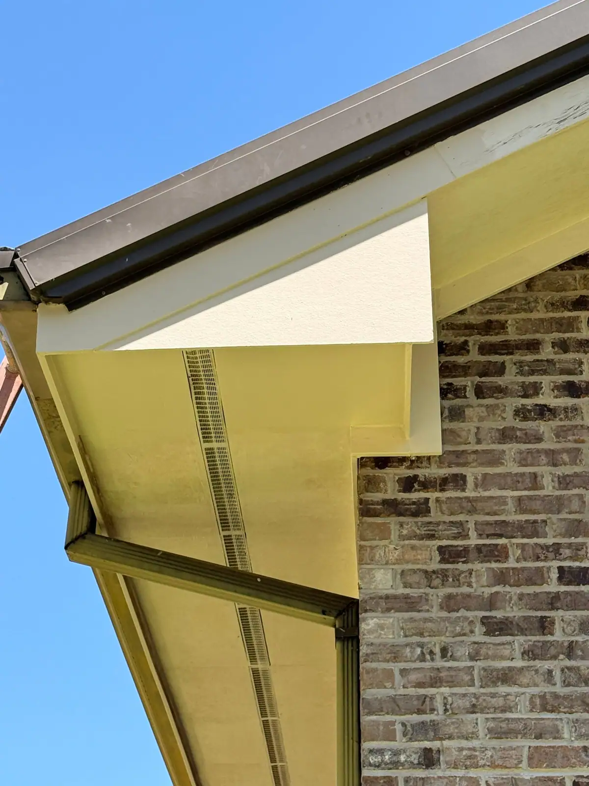 Rebuilt soffit and fascia with a continuous vent strip on a brick church