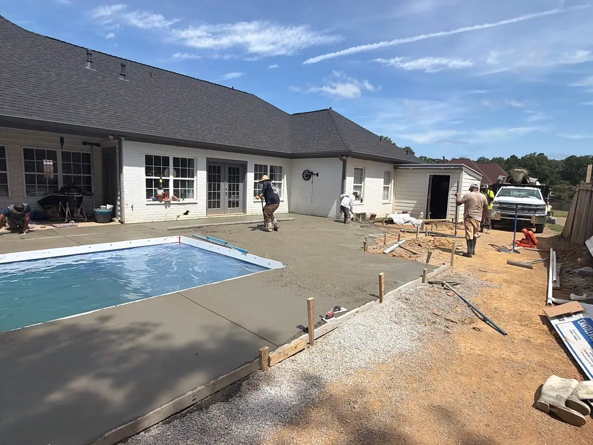 Concrete deck going in around a new fiberglass pool by DC Pools and Spas, pool company serving Clinton, MS