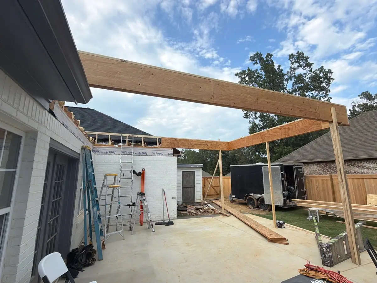 Posts and beam framed off the back of a house to cover a new outdoor kitchen