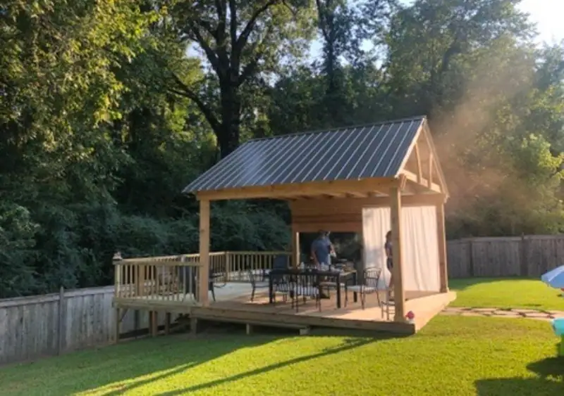 Finished pavilion with a metal roof on a raised wood deck, an outdoor living space