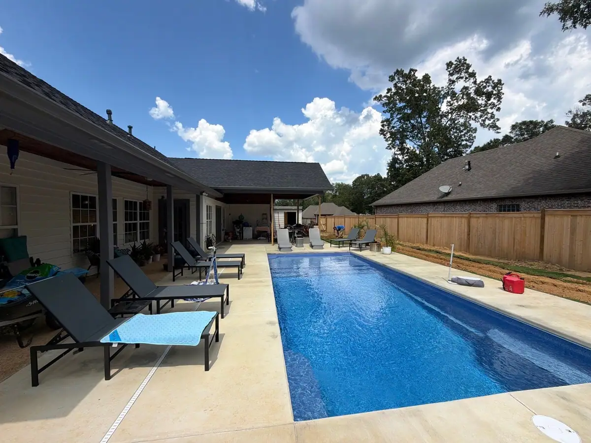 Completed fiberglass pool with its concrete deck by DC Pools and Spas, pool company serving Jackson, MS