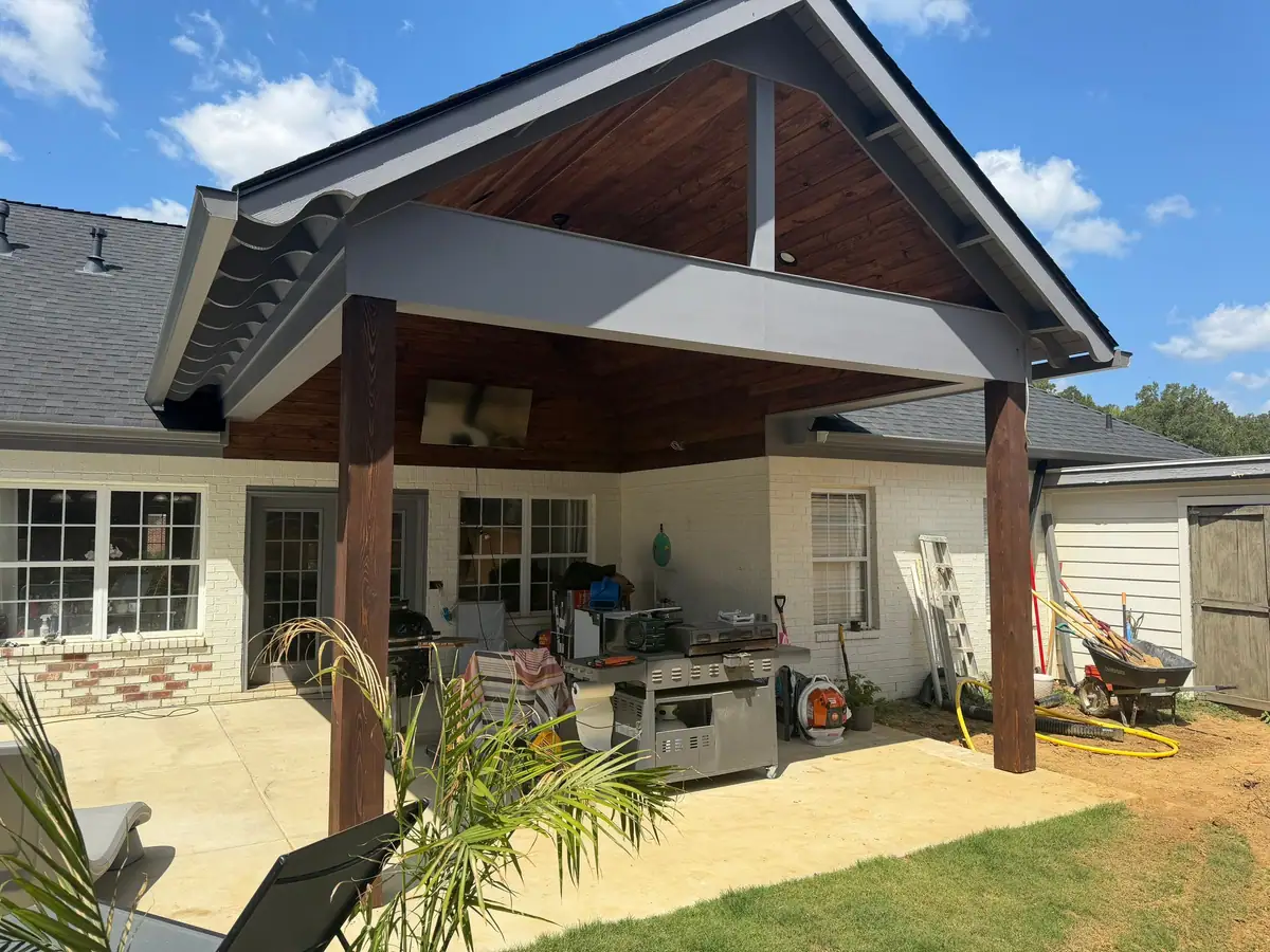 Covered backyard pavilion with a stained ceiling, timber posts and an outdoor kitchen grill station