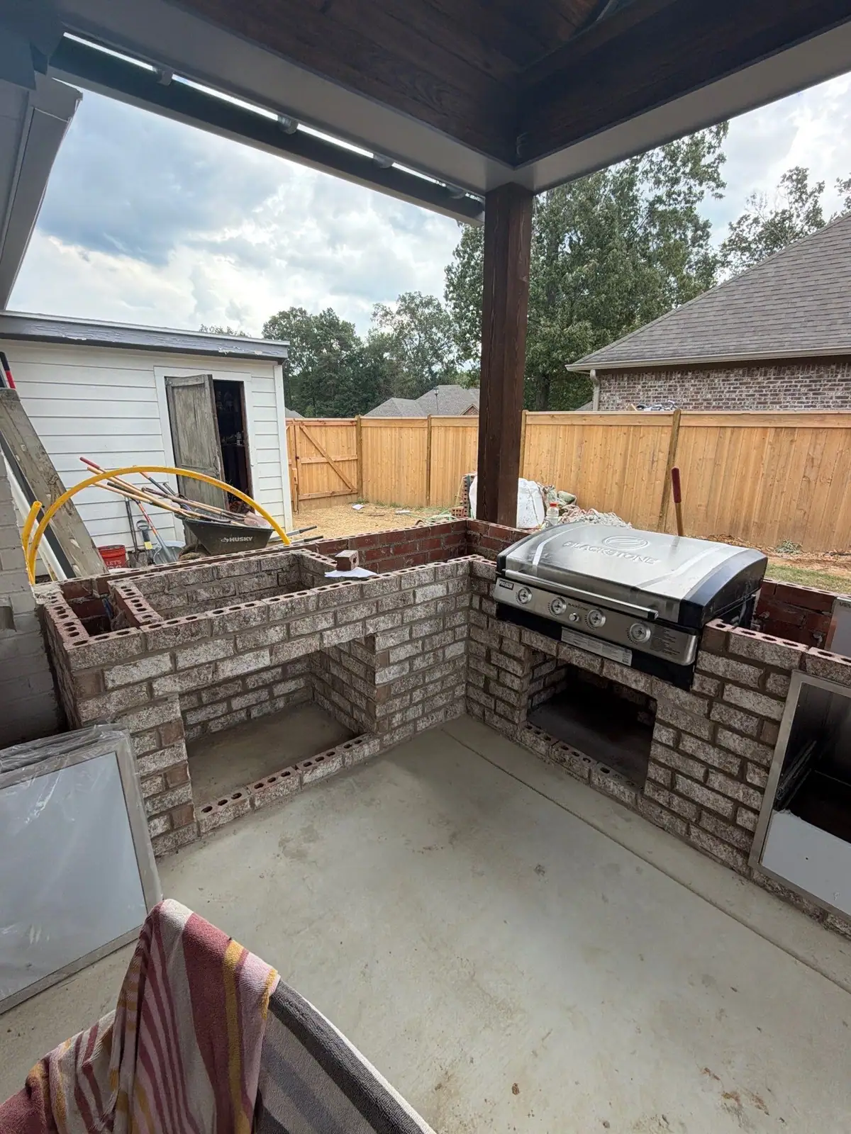 Brick outdoor kitchen base under a new cover with the grill set in place
