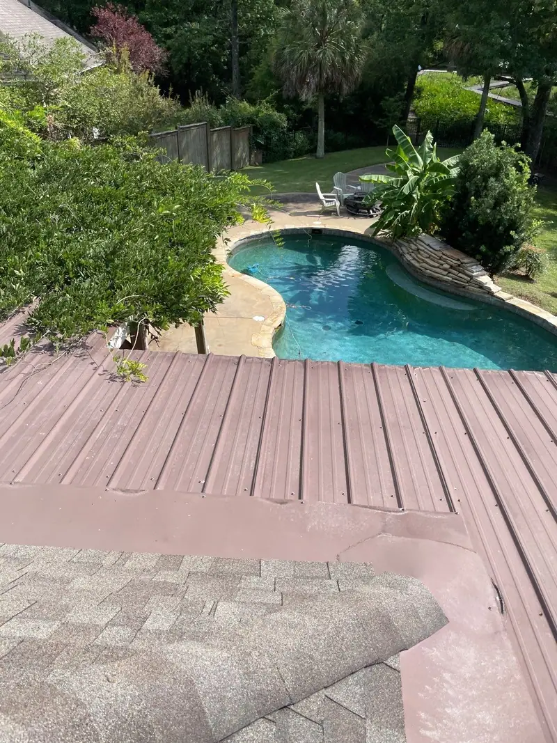 Metal roof section meeting a shingle roof above a backyard pool, metal roofing by Dickerson Contracting in Brandon, MS