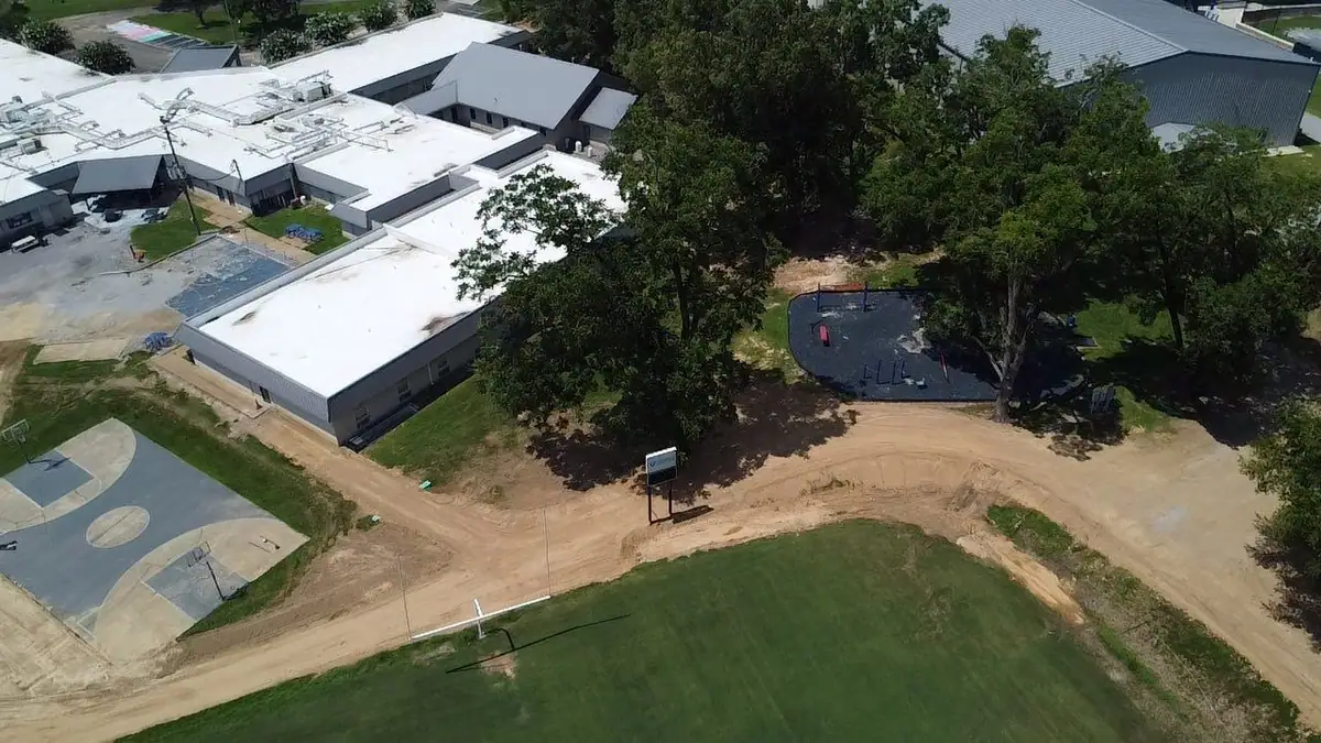 Aerial view of white flat roofs across a commercial campus, commercial roofing by Dickerson Contracting in Clinton, MS