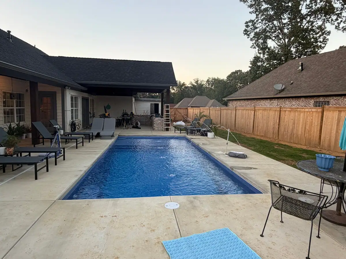 Rectangular fiberglass pool and patio behind a brick home, DC Pools and Spas serving Jackson, MS