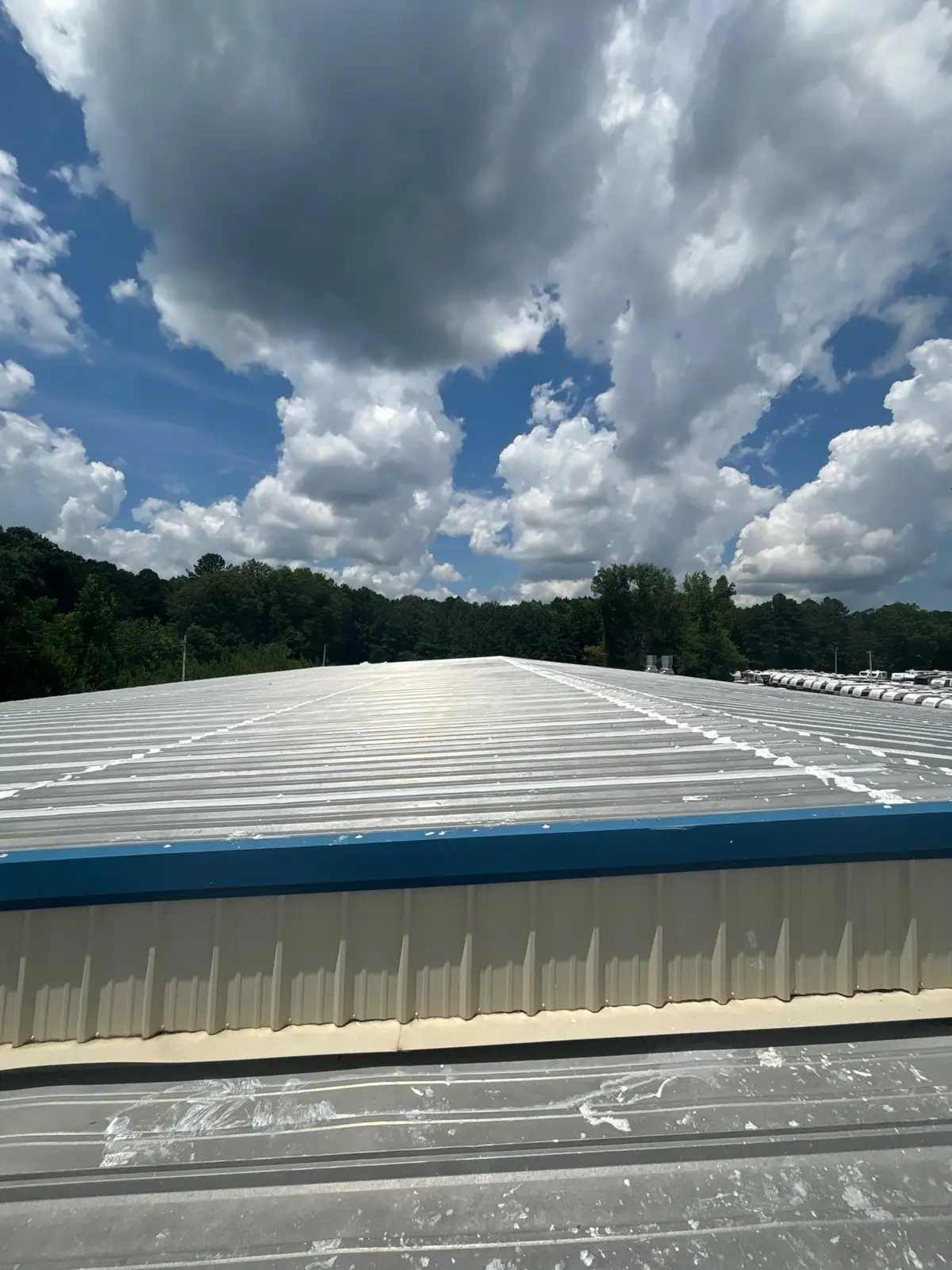New metal roof panels on a commercial building under a clouded sky, metal roofing by Dickerson Contracting in Jackson, MS