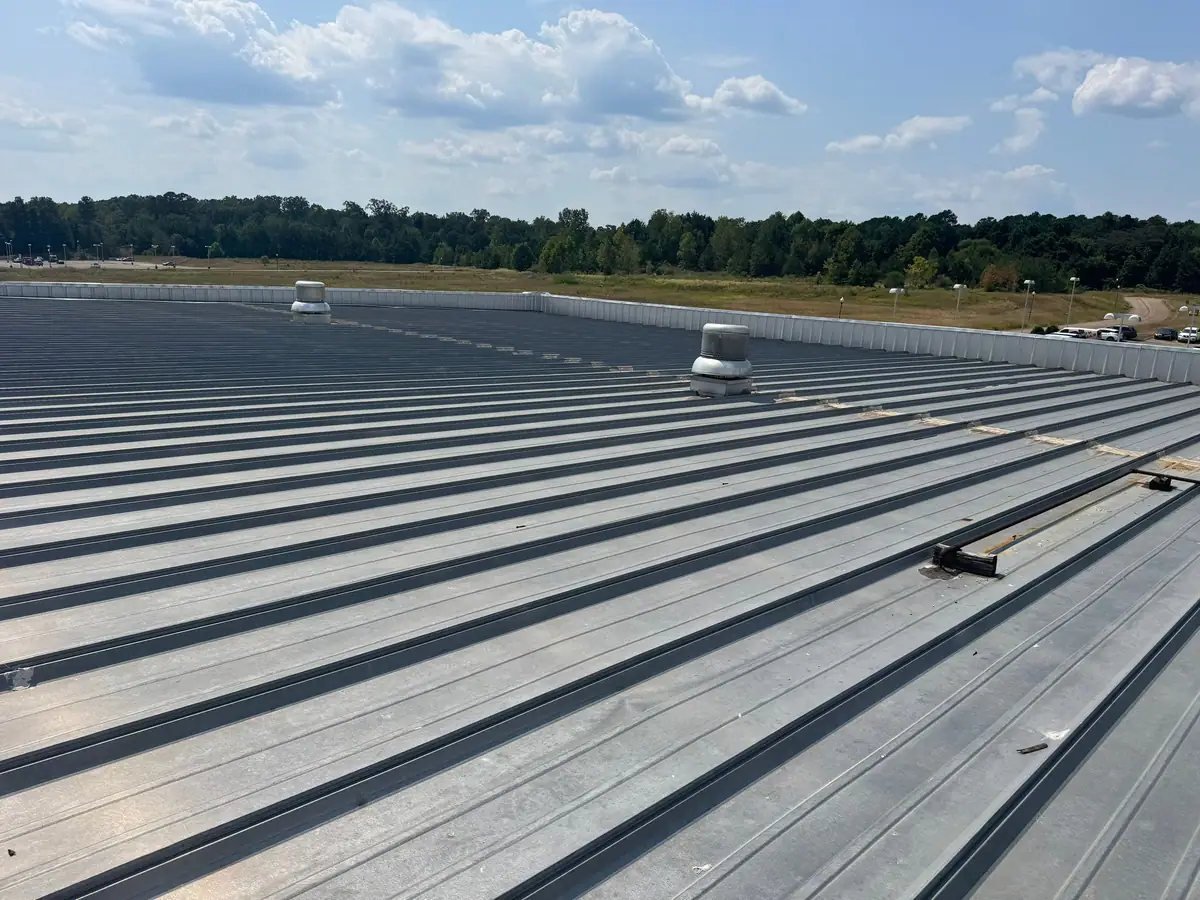 Wide run of new metal roof panels on a commercial building, metal roofing by Dickerson Contracting serving Jackson, MS