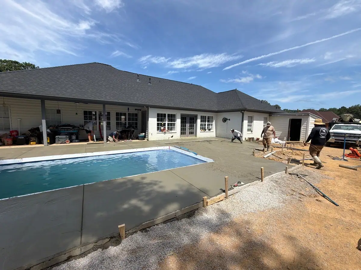 Concrete deck being poured around a new fiberglass pool, DC Pools and Spas pool company serving Jackson, MS