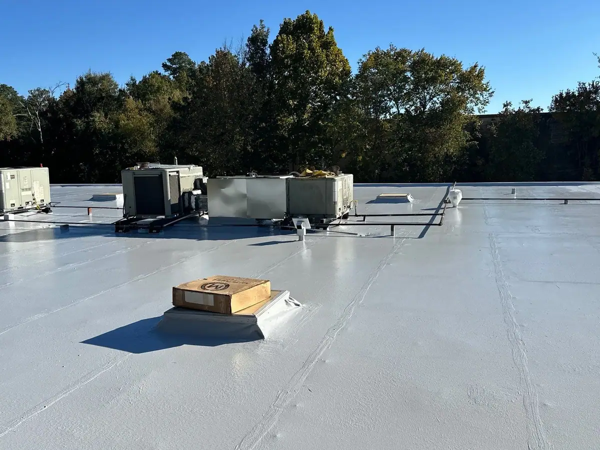 Finished white flat roof with rooftop HVAC units and a skylight, commercial roofing serving Madison, MS
