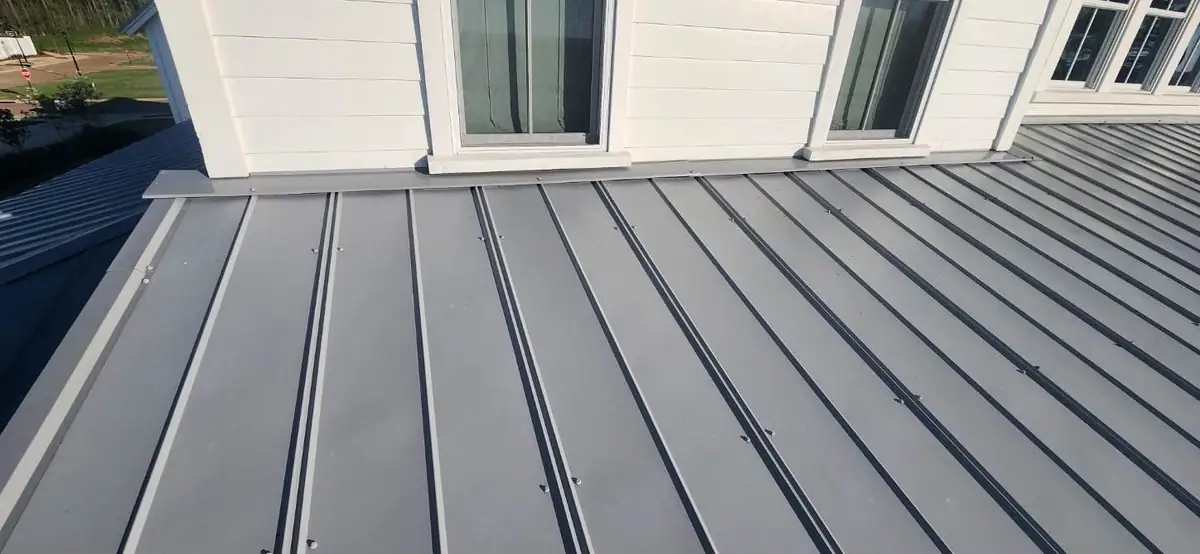 Standing seam metal roof below a row of second-story windows, metal roofing by Dickerson Contracting in Madison, MS