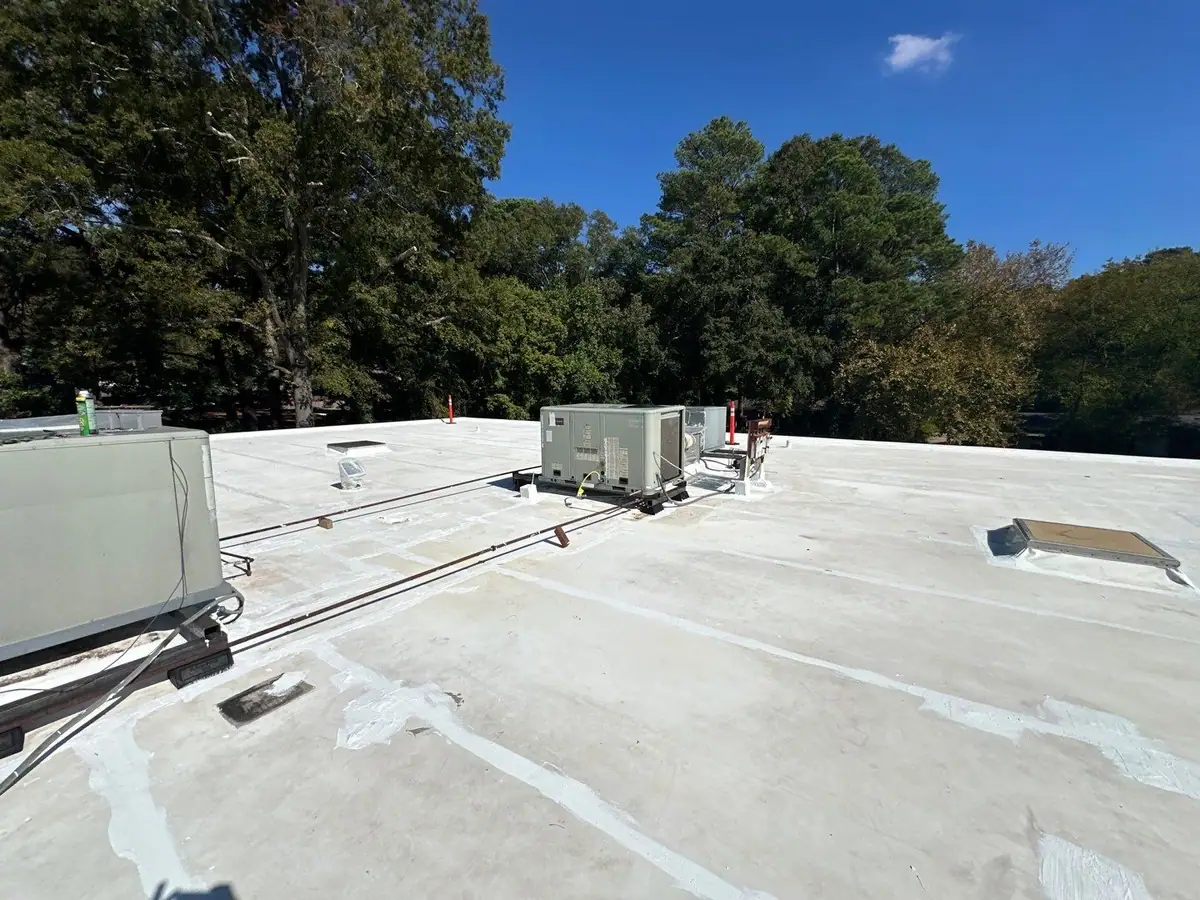 White flat roof membrane around rooftop HVAC equipment, commercial roofing by Dickerson Contracting serving Pearl, MS